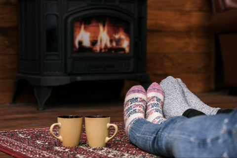 couple warming their feet by the fireplace