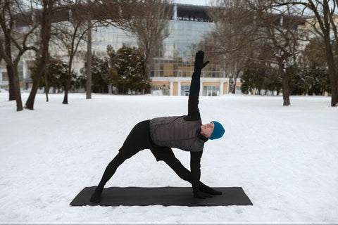 man doing yoga in the snow