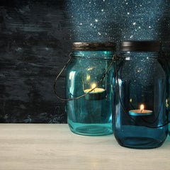 Two lanterns made from mason jars and votive candles