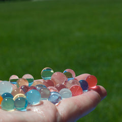 red, blue, and clear water beads in a hand