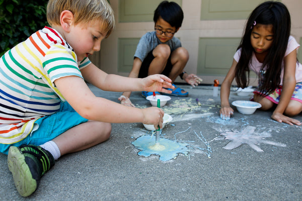 3 Kids exploring Fizzing Chalk Paint activity in the Sunny Summer Messy Play Kit