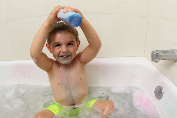 Child plays with water sensory play in the bathtub.