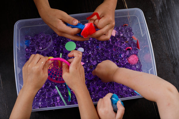 Kids reaching into a monster Halloween sensory bin