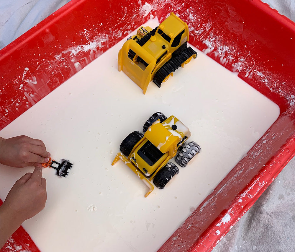 oobleck and construction vehicle toys in a red container