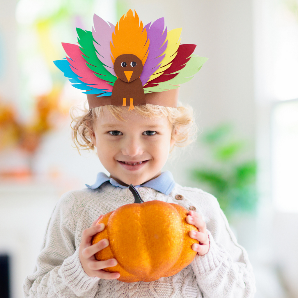 Child wears turkey crown Thanksgiving activity.