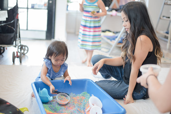 Child and mom practice rice sensory play.