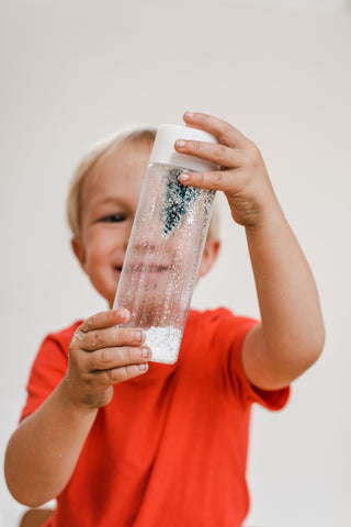 Child plays with a Christmas sensory bottle.