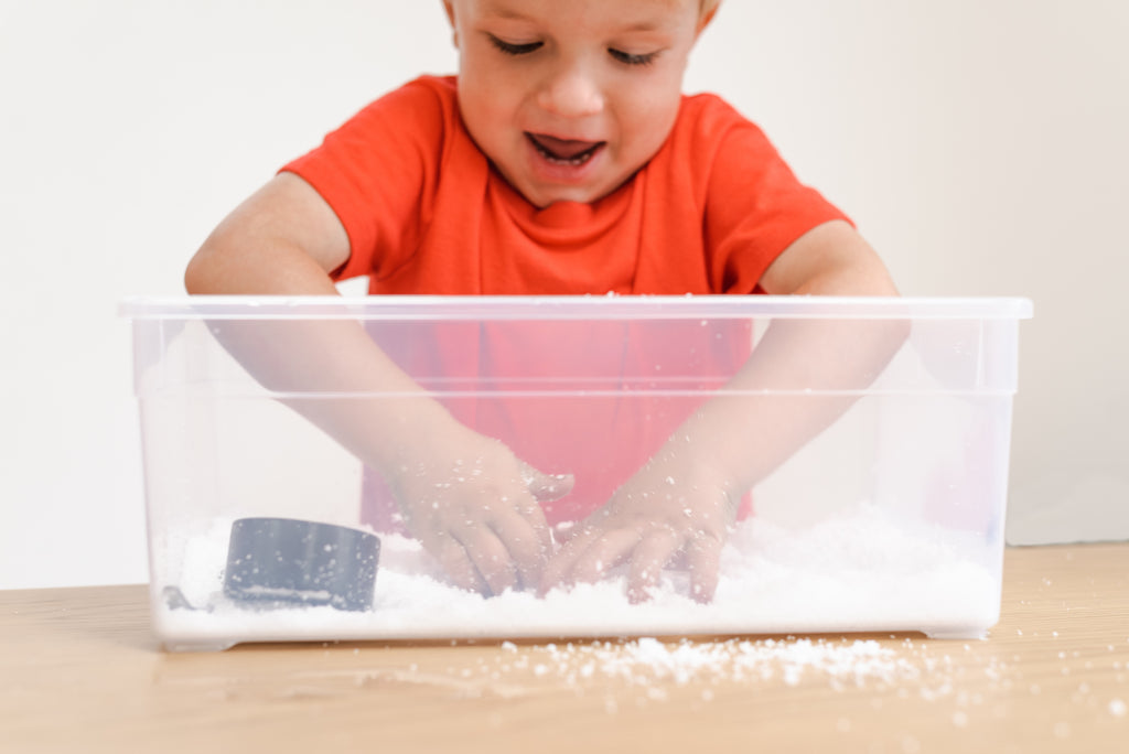 Child plays with fake snow.