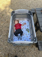 Messy Play Baby asleep in bed on road trip.