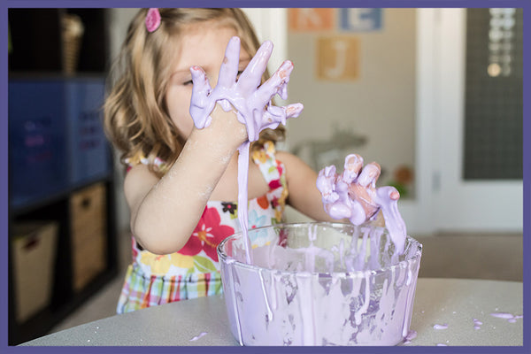 2 year old girl playing with an oobleck sensory activity