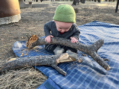 Messy Play Baby on blanket during road trip.