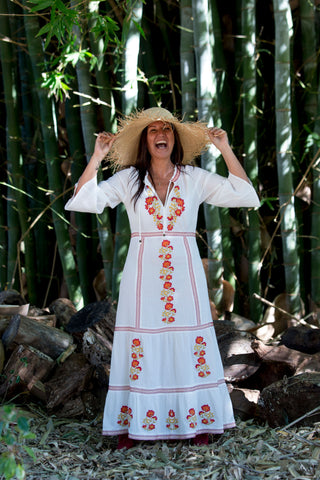 Girl in white dress and hat standing 