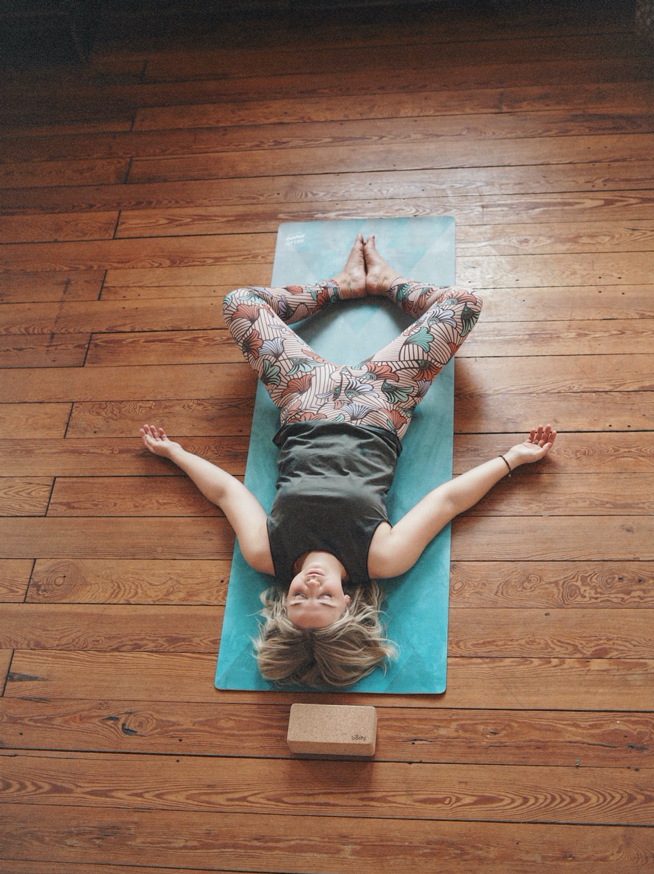 Young woman lying on yoga mat