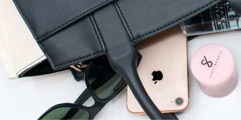 Black bag with phone sunglasses and makeup