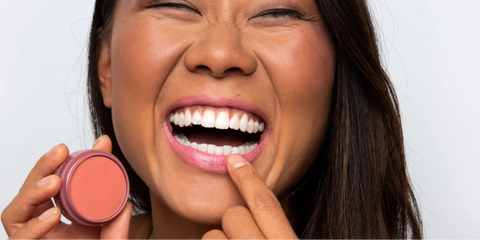 Woman smiling with a lip and cheek product