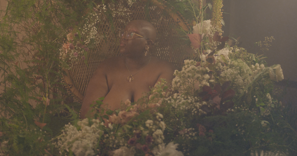 Margie describes impossible beauty standards and the impact on mental health. surrounded by a floral photoshoot wearing alternative jewellery hand made by Forage Design.