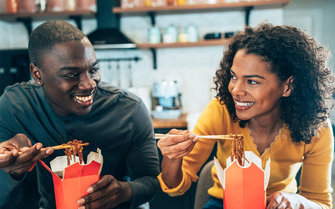 Couple eating takeaway noodles from a red carton. Chinese, Thai and Vietnamese food can be risky if you have nut allergiesCouple eating takeaway noodles from a red carton. Chinese, Thai and Vietnamese food can be risky if you have nut allergies