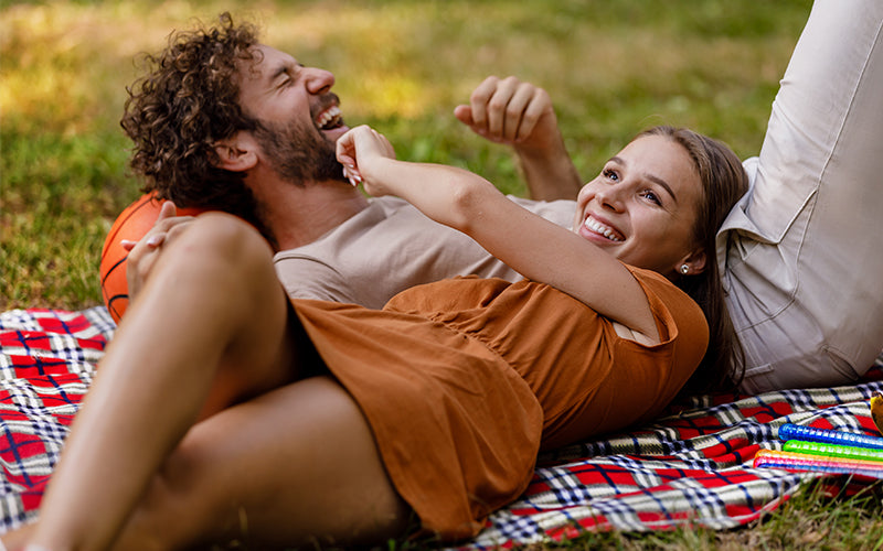 Young couple enjoying a summer afternoon on a blanket in the park. Not mid-morning or early evening when pollen levels peak 