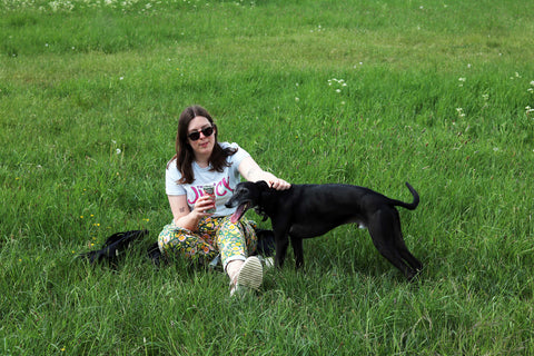Woman and dog sitting on the grass.