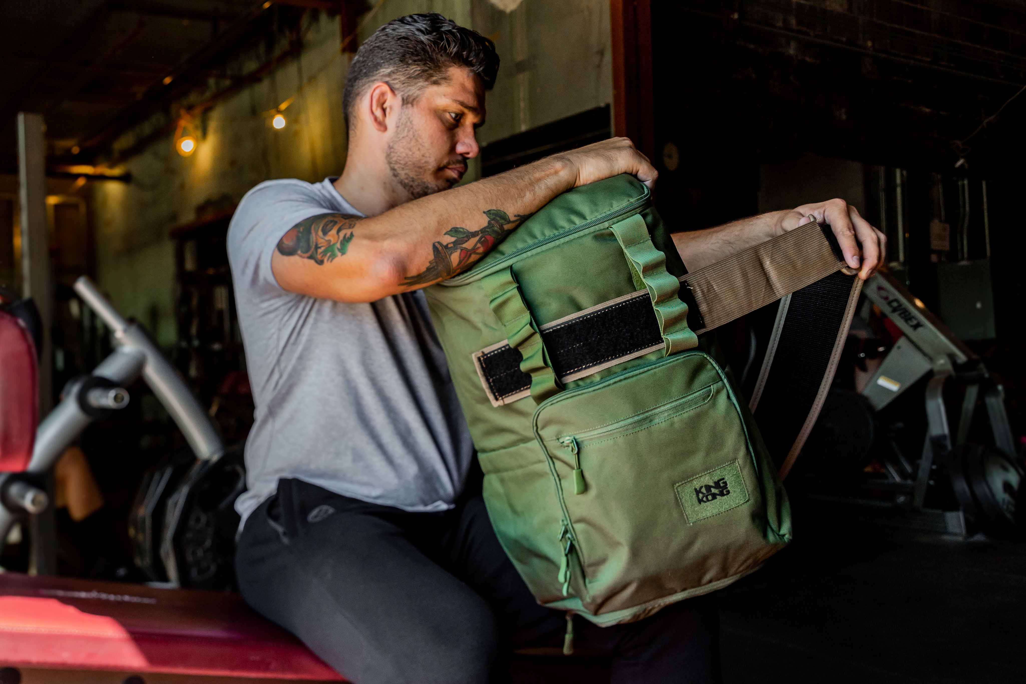 Green backpack with weightlifting belt compartment