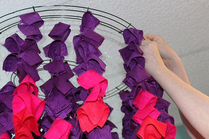 attaching the strands of folded scarve squares on wreath frames for the Ombre Scarf Chandelier