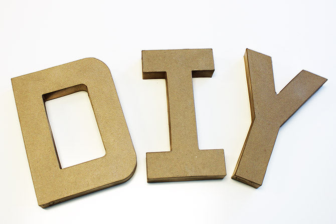 laying down the paper mache letters on paper for painting