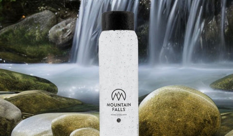 water bottle sitting in the middle of spring with waterfall in background