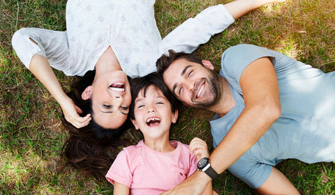 Mom, Dad and son laying down looking up and smiling and laughing