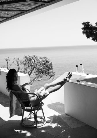 lady sitting in a chair while consuming mountain falls water (photo is in black and white)