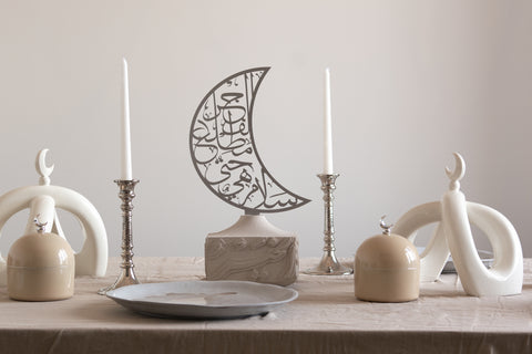 RASM cream crescent knot sculptures, artisan calligraphy base and sign, moon dome jars in desert sand on a tablescape