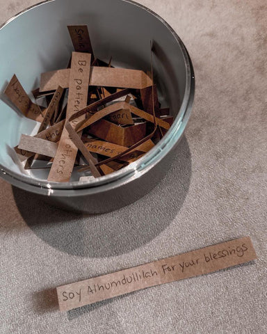 Open Moon Dome Jar with slips of paper inside.  Each paper has a daily activity to perform.