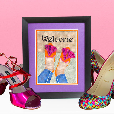 Finished and framed needlepoint canvas of shoes with tassels