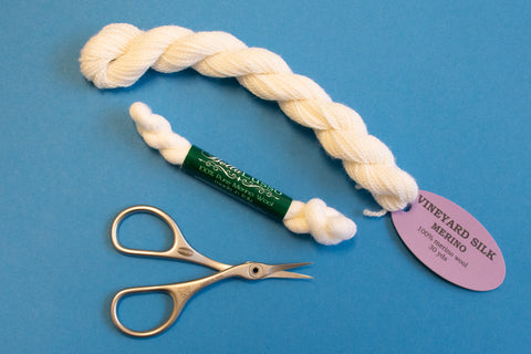 White needlepoint thread and curved scissors