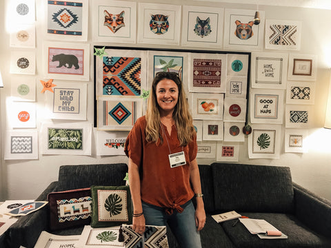 Tess in her booth at a needlepoint trade show