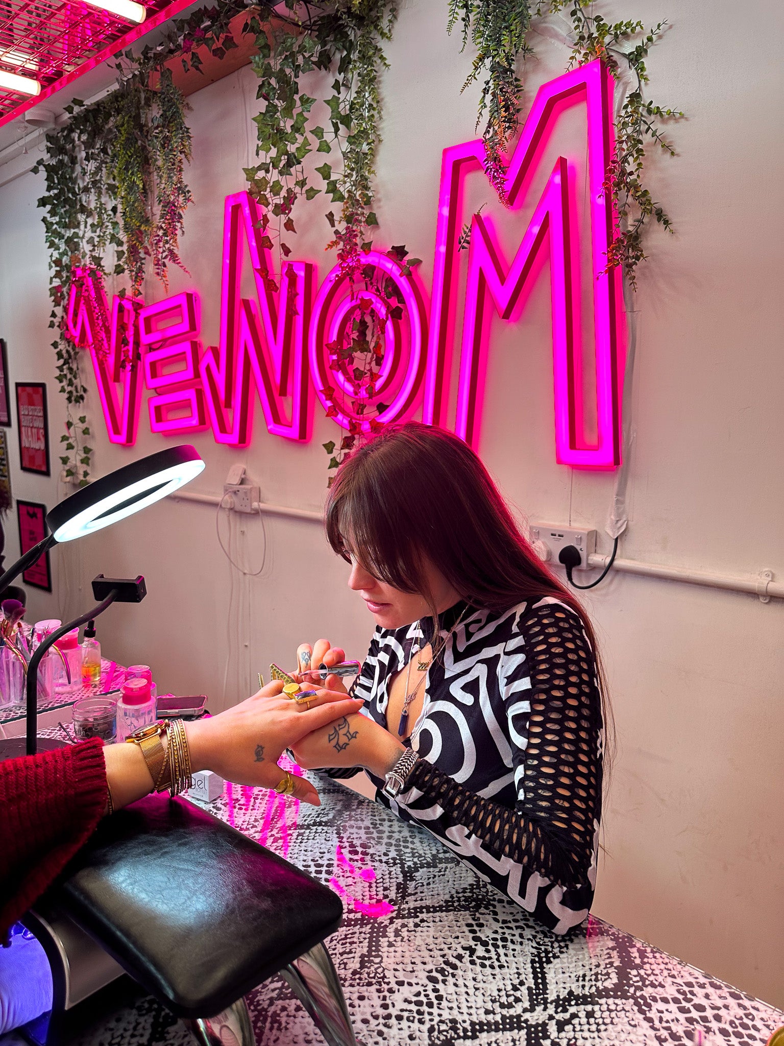DJ and nail artist APH, painting a clients nails in her Bristol pink salon, VENOM Creatives
