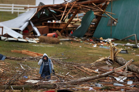 Man stands outside home devastated by Tornado in the Southern United States.