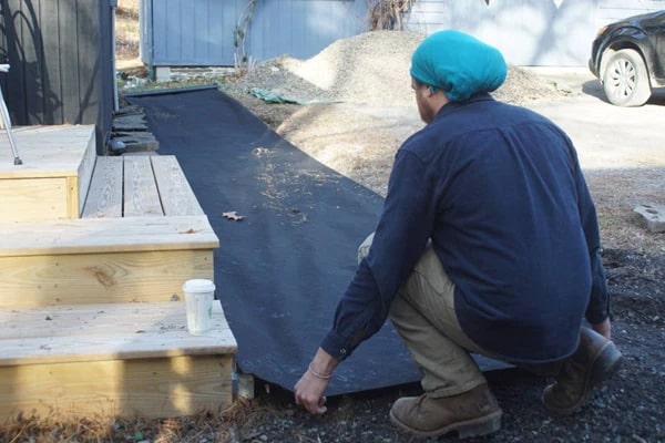 man laying out the Landscape fabric