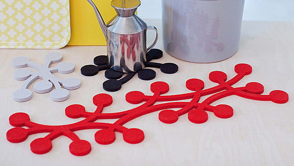 These trivets and table runners are from Verso Design, a Finnish design house that specializes in modern textiles and innovative home accessories inspired by nature. The design features berries on a vine, laser-cut from thick, felted wool.