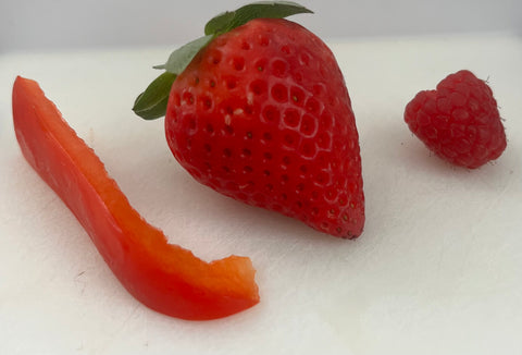 Picture of a slice of red pepper, a strawberry, and a raspberry