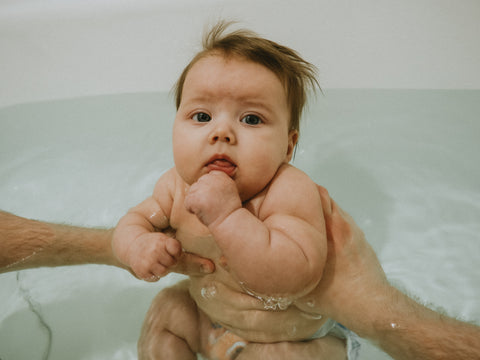 A warm bath can help relax your baby and signal that it's time for bed.