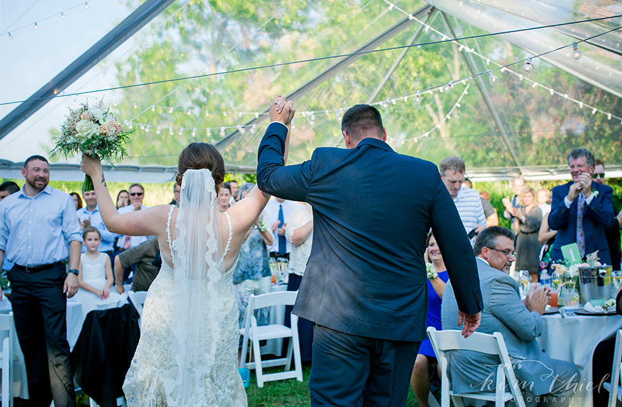 couple under a backyard wedding tent