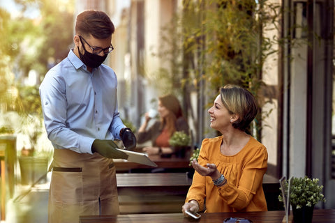 Waiter and visitor at the outdoor restaurant