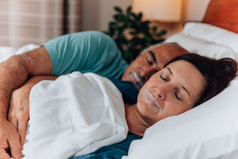couple sleeping with mouths taped shut