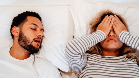 man snoring next to woman