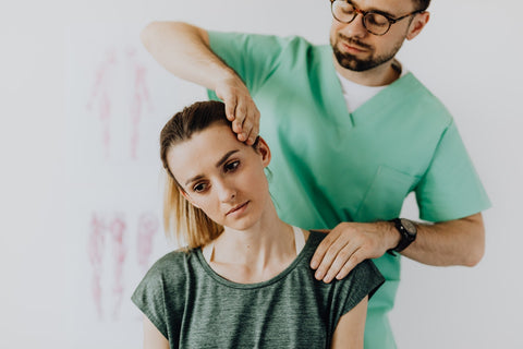 Massage therapist treats injured neck of female patient