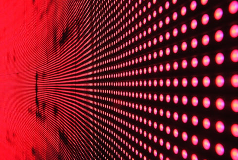 Red dot lights on a black surface. 