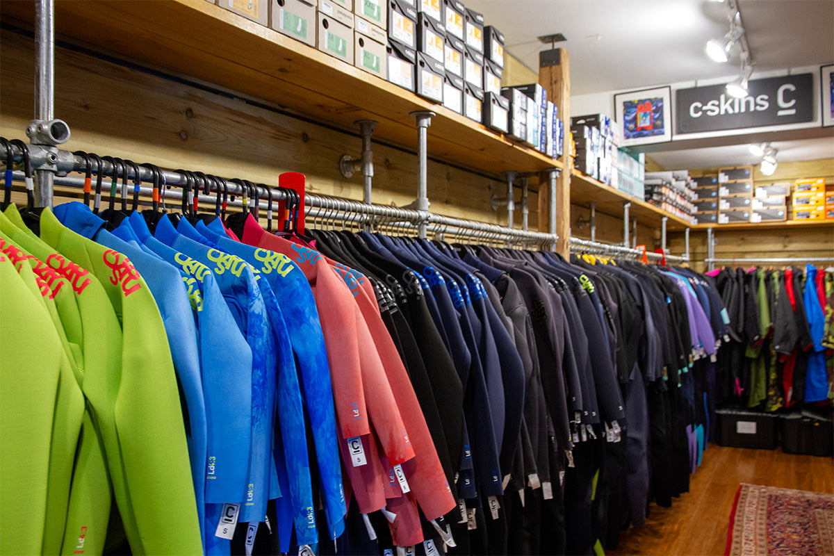 rack of c-skins wetsuits at down the line surf shop in cornwall