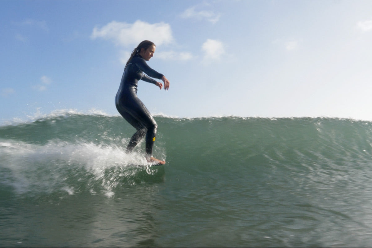 longboarder beth leighfield with toes over the nose of her surfboard, by bella bunce