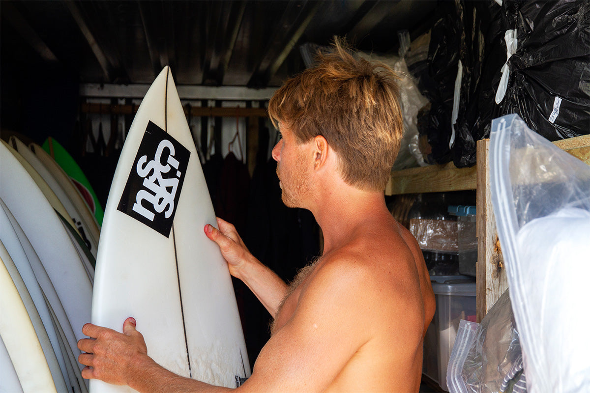 c-skins surfer jayce robinson selecting a surfboard from his quiver