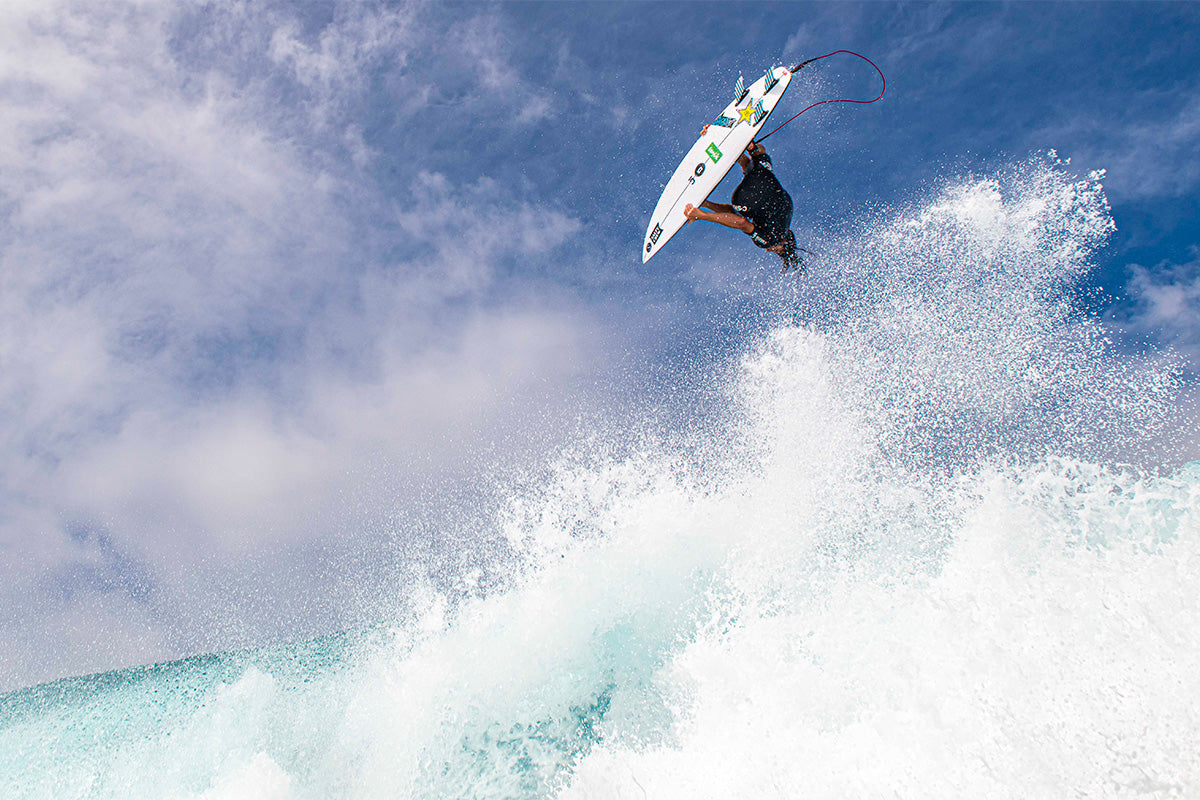 looking up at surfer matt meola boosting an inverted aerial over the head of surf photographer simon swilly williams